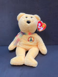 Yellow beanie baby bear with multicoloured peace symbol and scarf