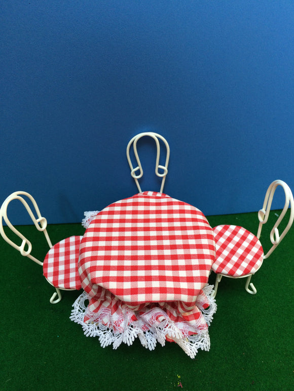 White wire table with four chairs, red check cloth perfect for an outdoor wedding